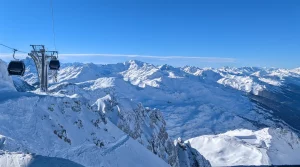Blick auf die weitläufige verschneite Tiroler Landschaft mit einem Gondellift auf der linken Seite