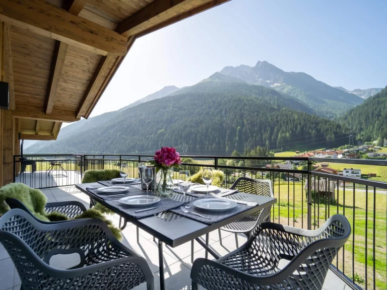 Terasse mit Esstisch und Ausblick auf die Berge der TOP-3 Wohnung