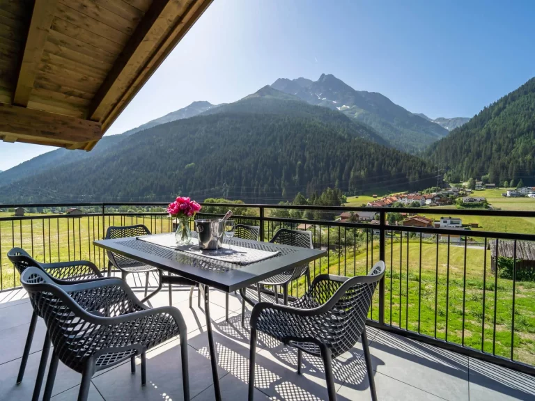 Terasse mit Esstisch und Blick auf die Berge der TOP-4 Wohnung